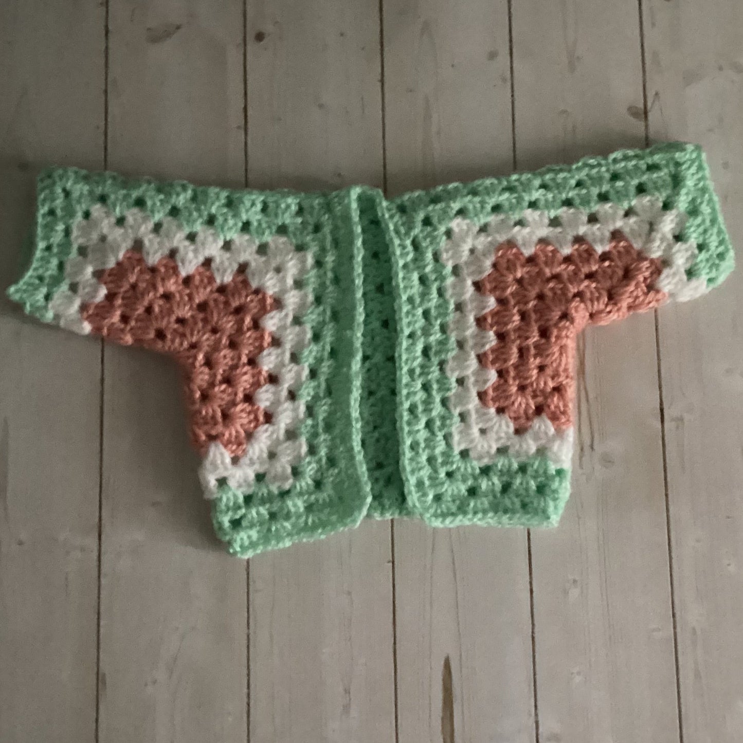Crocheted heart-patterned item on a wooden surface