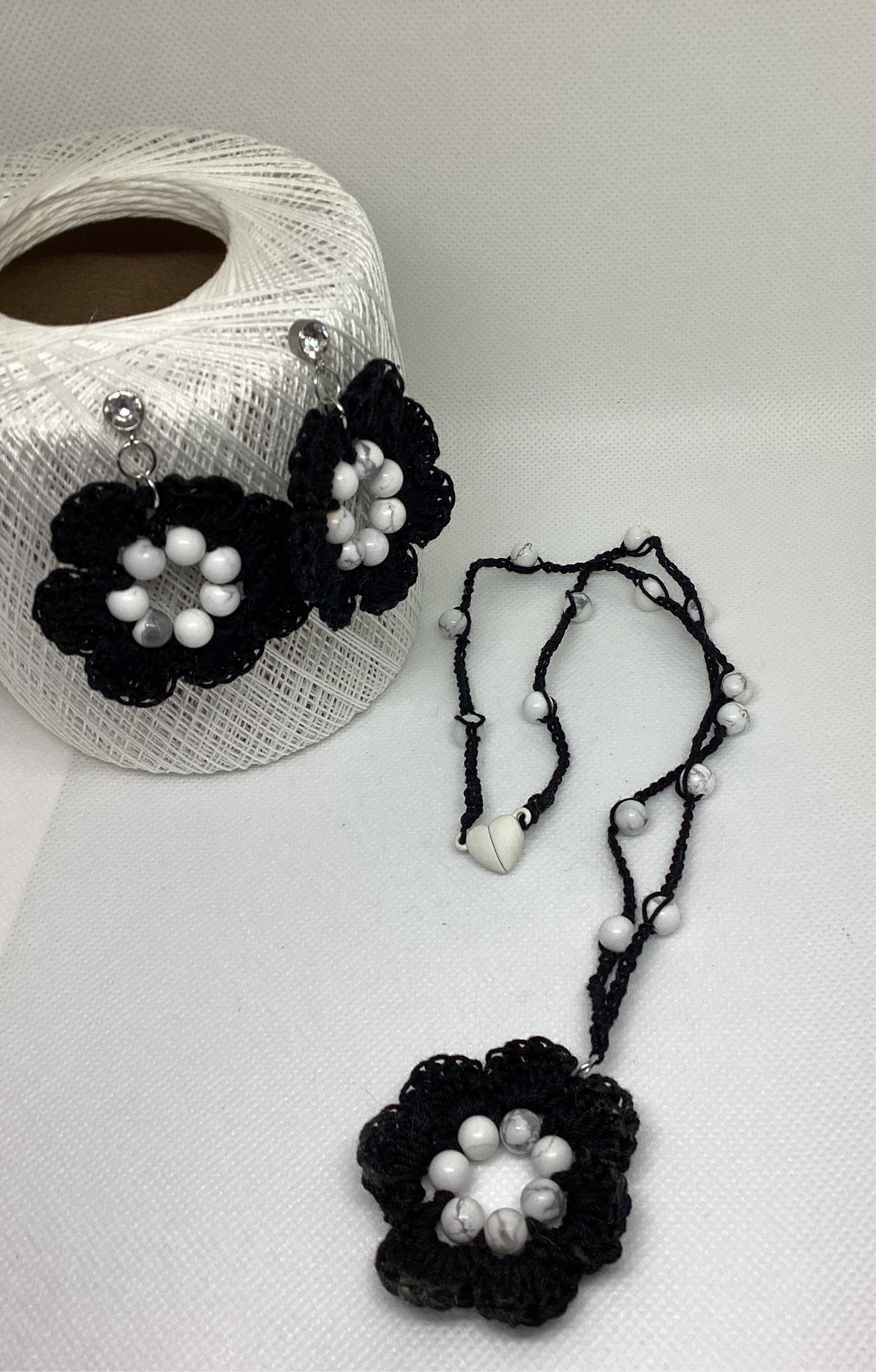 black flower necklace and earring set, made with white howlite beads, flower necklace has a magnetic heart clasp, earring have a rhinestone stud