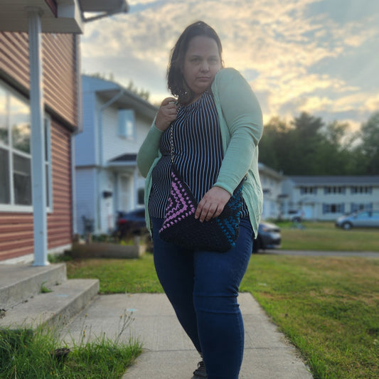 Person standing on a sidewalk with houses and grass in the background