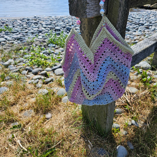 vibrant beach bag  color green purple pink  blue  with pink and white handles 